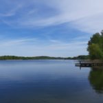 a body of water surrounded by trees and a dock