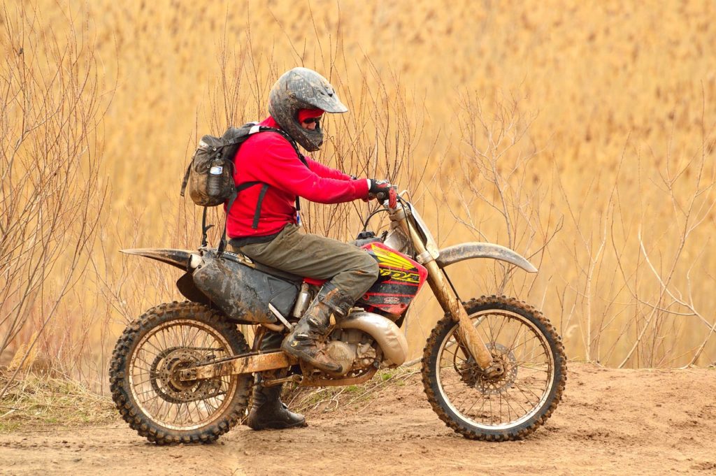 Motocyklista jadący drogą w słoneczny dzień