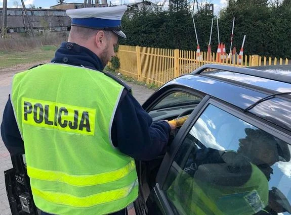 Policjant kontrolujący stan trzeźwości kierowcy w Piszu