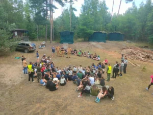 Strażacy PSP Pisz prowadzą zajęcia edukacyjne na obozie harcerskim nad jeziorem